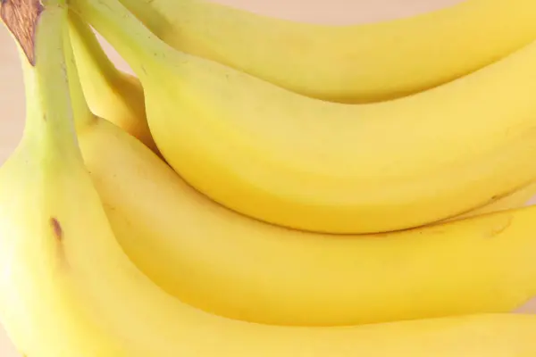 明るい背景に新鮮な熟したオーガニックバナナのクローズアップビュー — ストック写真