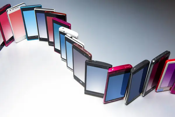 Moderne Mobiele Telefoons Met Verschillende Kleuren Grijze Achtergrond — Stockfoto