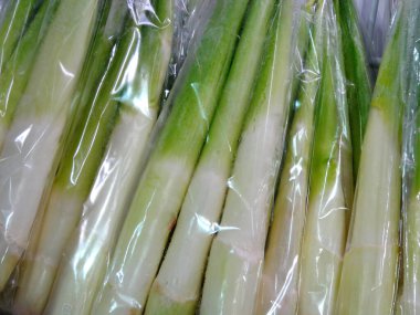 Beyaz arka planda taze yeşil kuşkonmaz