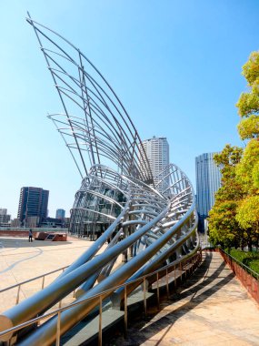 Katmanlı bir perspektif, parlak bir gökyüzü altında uzanan modern şehir yapılarını yakalar..