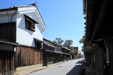 Mavi gökyüzünün altında ahşap binaları olan geleneksel Japon caddesi.