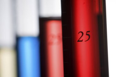 Beyaz arkaplanda renkli sıvılarla dolu test tüplerinin yakın plan görüntüsü       