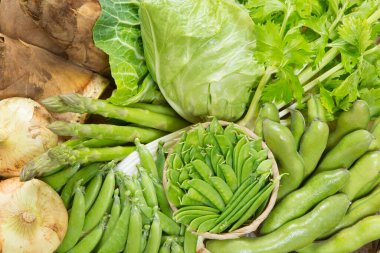 Tahta kutuda taze yeşil organik sebzeler. Yeşil bezelye, lahana, ot, soğan, kuşkonmaz, bambu filizi. 