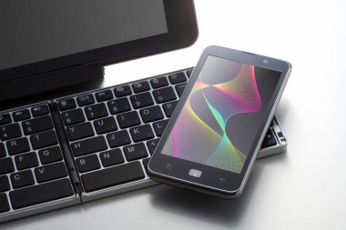Beyaz arkaplanda bilgisayar klavyesinin ve cep telefonunun yakın görüntüsü                 