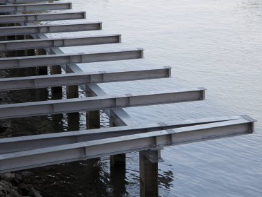 İnşaat aşamasında sakin suyun üzerine uzanan metal kirişler