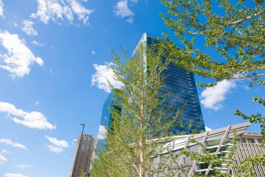  Gökdelenler, mavi gökyüzü ve Tokyo, Japonya 'da yeşil ağaçlar 