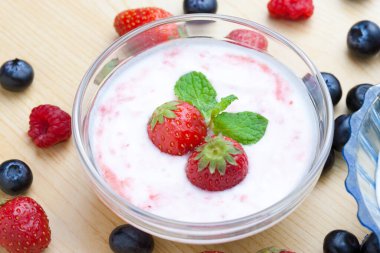 Masadaki yoğurtta taze çilek.