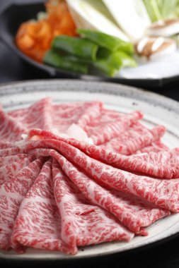 Lezzetli wagyu sığır eti dilimleri ve taze sebzelerin yakın görüntüsü.        