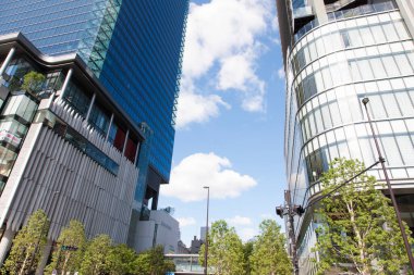  Gökdelenler, mavi gökyüzü ve Tokyo, Japonya 'da yeşil ağaçlar 