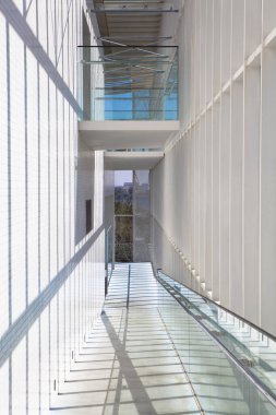 Camdan yürüme ve beyaz duvarları olan modern mimari