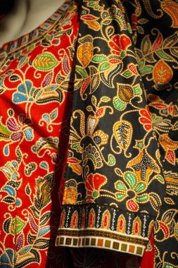 Renkli kumaş. Karmaşık çiçek desenleri ve tasarımlar gösteriyor.