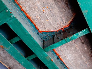 Kaba beton tavan yapısını destekleyen yeşil çelik kirişleri gösteren yakın plan