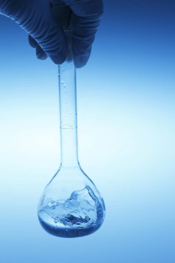 Elinizde cam matara ve sıvı var. kimyasal deney konsepti