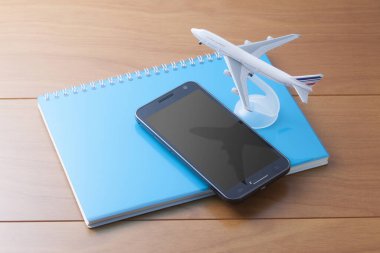 Ahşap masaya yerleştirilmiş akıllı telefon modeli bir defter.