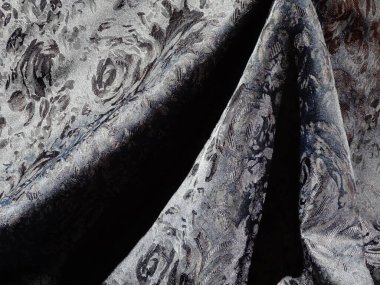 Kalıplı kumaş gri ile karışık çiçek desenleri sergiliyor.