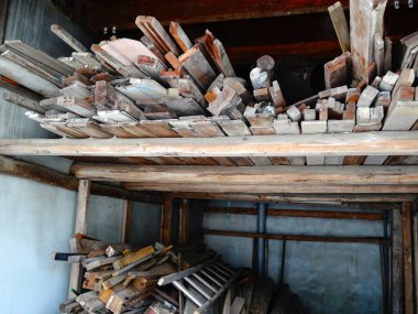 Köy deposunun iç kısımlarında eski ahşap kalaslar yığılıyor.