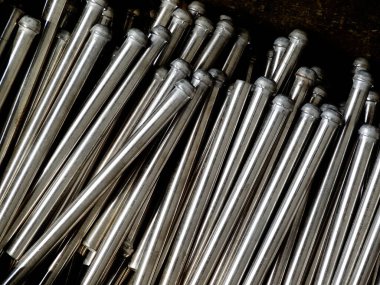 Metalik beyzbol sopaları üst üste dizilmiş.