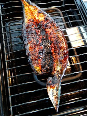Baharatlı ve soslu ızgara balığın yakın plan görüntüsü.