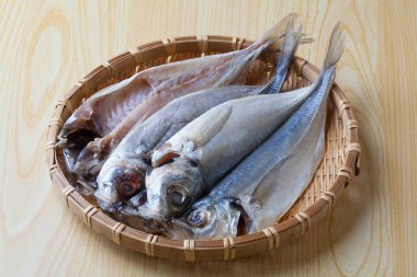 Tahta masadaki bambu sepetinde taze uskumru balığı.