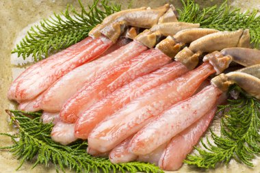 Tabağında yeşil otlar olan taze çiğ yengeç yiyeceği, yakın plan görüş.       