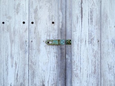 Beyaz bir duvar yüzeyindeki kapının kilidini yakından çek.