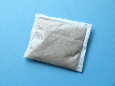 Mavi arka planda bitki çayı poşeti.