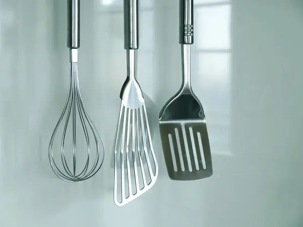 kitchen tools and utensils hanging on the wall