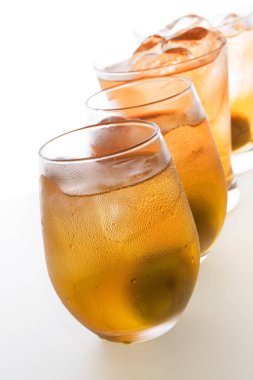 Beyaz zemin üzerinde alkol ve buz küpleri olan bardaklar.                   