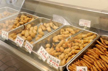 Tepsilerde çeşitli kızarmış abur cuburlar gösteriliyor