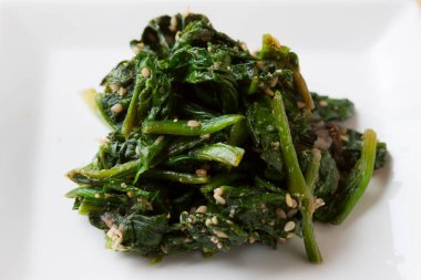 Beyaz tabakta kızartılmış ıspanak