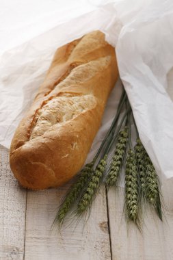 Masa arkasında taze ekmek ve buğday kulaklarının yakın plan görüntüsü              