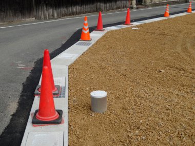 Yol inşaatı detayları, parlak turuncu trafik konileri.