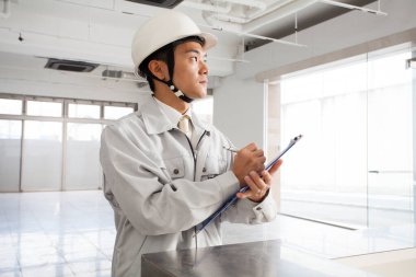 İnşaat alanında üniformalı yakışıklı bir mimarın portresi.