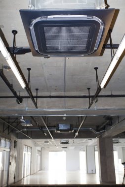 Gri duvarları ve boruları olan endüstriyel yapı.         