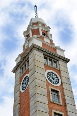 Parçalı bulutlu gökyüzüne karşı tarihi tuğla saat kulesi