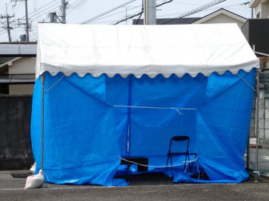 Asfalt yolda sandalyeli boş mavi çadır