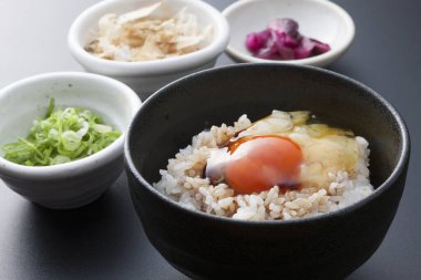 Çiğ yumurta ve taze sebzeli bir kase lezzetli pirinç, geleneksel Japon mutfağı.