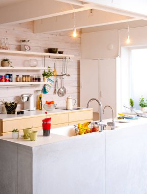 Modern mutfakta asılı ışıklar ve açık raflar var.