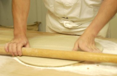 Fırıncı arka planda tahta tahtada hamur yapıyor, kapat.