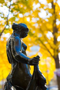 Sonbahar yapraklarına karşı bronz heykel