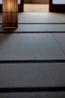 Yumuşak ışık geleneksel tatami paspas döşemesini aydınlatıyor.