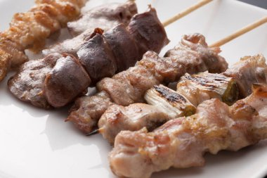 Beyaz tabakta şişler olan leziz ızgara et manzarası       