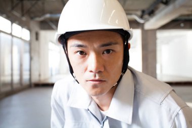 İnşaatta üniformalı yakışıklı Asyalı mühendis.