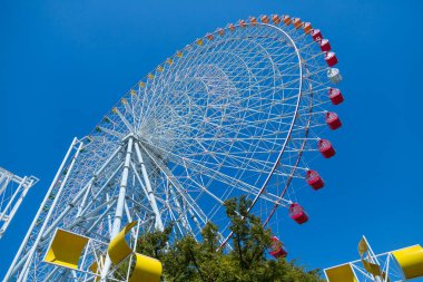 Mavi gökyüzü arka planındaki lunaparkta dönme dolap.