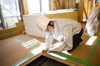 Ahşap binayı inceleyen Asyalı genç inşaat müfettişinin portresi.