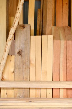 Atölye depolama alanında duvara yaslanmış ahşap tahtalar.