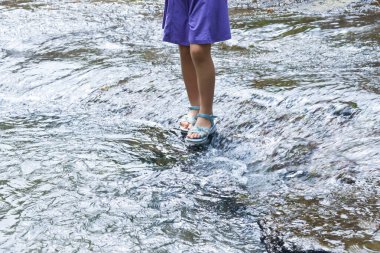 Sığ sularda sandalet giyerek durmak