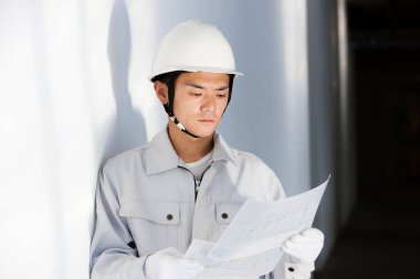 İnşaat alanında üniformalı yakışıklı bir Japon inşaatçının portresi.