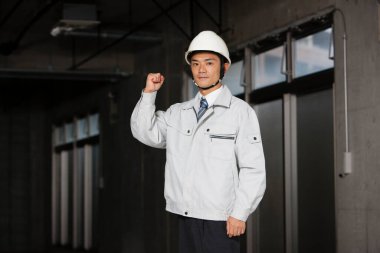 İnşaatta üniformalı yakışıklı Asyalı mühendis.