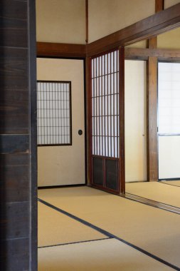 Geleneksel Japon tatami odasında sürgülü Shoji kapıları ve ahşap çerçeveler var.